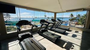 a gym with three treadmills and a view of the ocean at Flat 337 vista lago no Lake side in Brasília