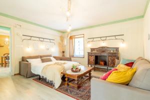 a living room with a bed and a couch and a table at Dimora Pellegrino in Torre Pellice