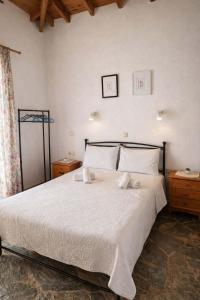 a bedroom with a large bed with white sheets and pillows at Oasis Studios Skala Kallonis in Skala Kallonis