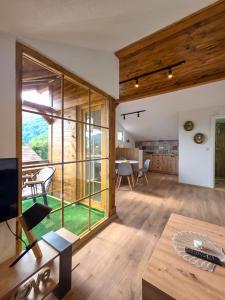 a living room with a large window and a dining room at na obali drine in Perućac