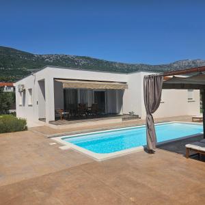 eine Villa mit Swimmingpool und einem Haus in der Unterkunft SunN Joy in Kaštela