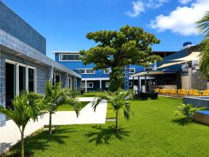 a courtyard with palm trees in front of a building at Hotel Summer Beach Paripueira Maceió in Paripueira