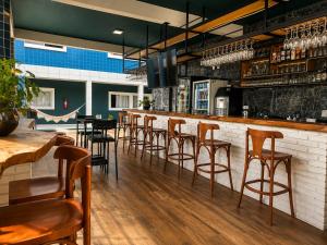 a bar with wooden stools in a restaurant at Hotel Summer Beach Paripueira Maceió in Paripueira