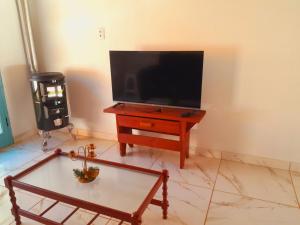 a living room with a tv and a coffee table at Recanto do Gigante Adormecido in Joanópolis