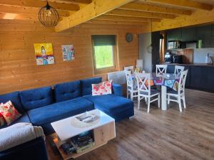 a living room with a blue couch and a table at Domek wakacyjny Domysłów in Domysłów +6 photos
