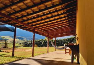 a porch with a hammock under a wooden pergola at Recanto do Gigante Adormecido in Joanópolis