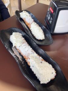 two pieces of cake on black plates on a table at La Gorgonia in Trapani