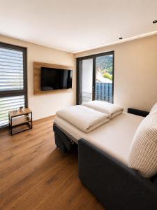 a bedroom with a large bed and a flat screen tv at NEU ab Juli 2026 - Apart Kneringer in Prutz