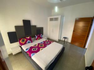 a bedroom with a large bed and a wooden door at Chamber double in Saly Portudal