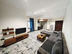 a large living room with a couch and a tv at Sky Airport Hotel - فندق سما المطار in Al Mawşil