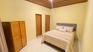 a bedroom with a bed and a wooden ceiling at Casa no Centro Vilhena in Vilhena