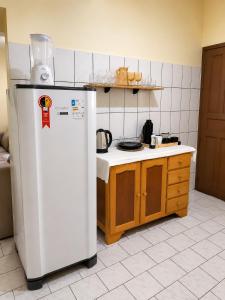 a kitchen with a white refrigerator and a counter at Casa no Centro Vilhena in Vilhena
