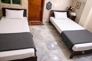 two beds sitting in a room with at AZH Hotel & Rooms in Islamabad