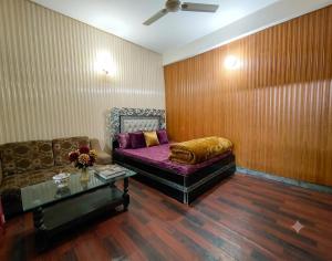 a living room with a couch and a coffee table at AZH Hotel & Rooms in Islamabad