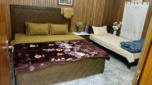 a small bedroom with two beds and a bedskirts at AZH Hotel & Rooms in Islamabad