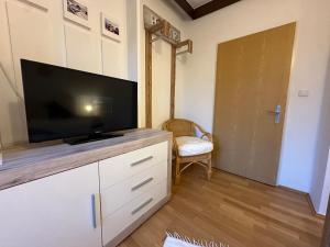 a living room with a flat screen tv on a cabinet at Max and Moritz Top 7 in Liebenau