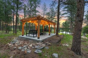 a gazebo with benches and lights in the woods at Hottub Haven BHBungalows #9 in Custer