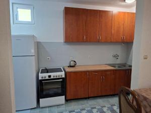 a kitchen with a white stove and wooden cabinets at Mareza in Podgorica