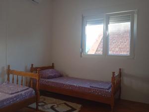 two beds in a room with a window at Mareza in Podgorica