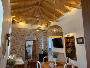 a dining room with a table and a chandelier at Leonidas house hydra in Hydra