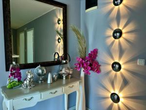 a bathroom with a vanity with a mirror and purple flowers at Art-Villa SeLena in Bar +108 photos