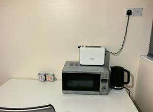 a microwave sitting on top of a counter at DD Private Double Room with Shared Bathroom in York +2 photos