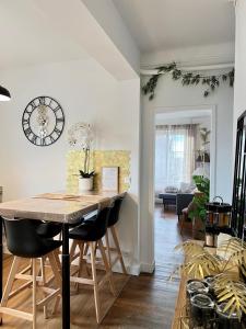 a living room with a table and chairs and a clock at La pause Saumuroise in Saumur +13 photos
