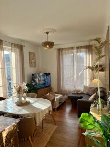 a living room with a table and a couch at La pause Saumuroise in Saumur