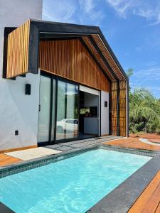 a house with a swimming pool in front of it at Cabana Komodo Bonito in Bonito