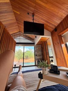 a person laying on a bed in a room with a tv at Cabana Komodo Bonito in Bonito