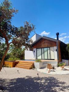 a house on the beach with a bench in front of it at Cabana Komodo Bonito in Bonito