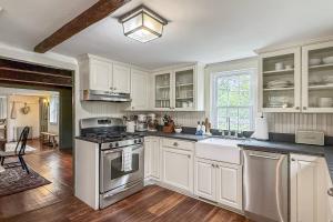 a kitchen with white cabinets and a stove top oven at Bluestone Cottage in Goshen