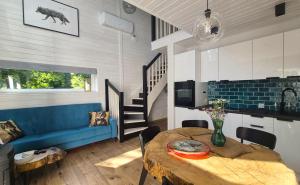 a dining room with a table and a blue couch at Las Tu Las Tam in Chudaczewko