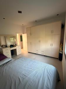 a bedroom with white cabinets and a large bed at Villa Hasani in Hamallë