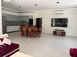 a living room with a table and chairs and a tv at Villa Hasani in Hamallë