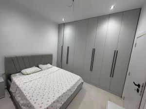 a bedroom with a bed and white cabinets at Villa Hasani in Hamallë +2 photos