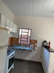 a kitchen with a sink and a stove at Casa tranquila próximo ao centro e a Unigran in Dourados +2 photos