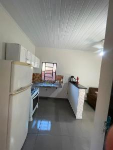 a kitchen with a white refrigerator and a stove at Casa tranquila próximo ao centro e a Unigran in Dourados
