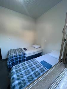 a room with two beds in a room withthritisthritisthritisthritisthritisthritisthritis at Casa tranquila próximo ao centro e a Unigran in Dourados