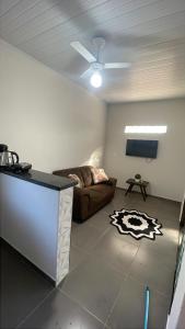 a living room with a couch and a ceiling fan at Casa tranquila próximo ao centro e a Unigran in Dourados