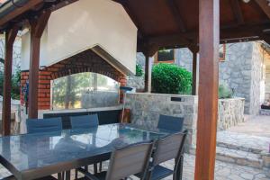 a table and chairs on a patio with a stone wall at Sunny oasis in Marčelji