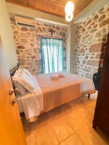 a bed in a room with a stone wall at Kyma in Gerolimenas