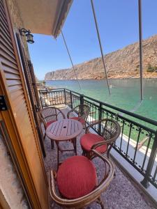 a balcony with chairs and tables and the water at Kyma in Gerolimenas
