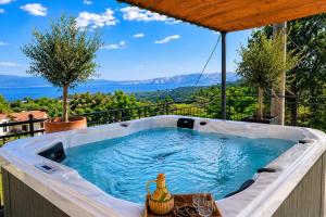 a hot tub on the balcony of a house at Villa Nona Tamara with Astonishing Sea & Mountains View in Bribir