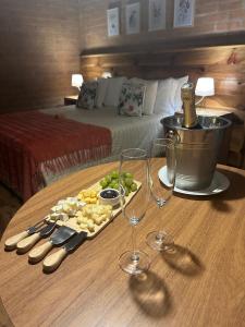 a tray of food and wine glasses on a table in a hotel room at Chalés Ceuci in Santo Antônio do Pinhal +20 photos