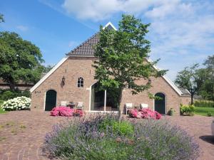 a brick building with flowers in front of it at De Oranjehoeve in Holthone