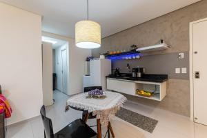 a kitchen with a table and a small kitchen with a refrigerator at Apartamentos com internet rápida in Maceió
