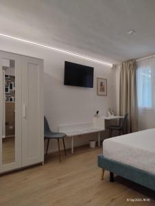 a bedroom with a bed and a desk with a tv on the wall at Turistica Via Po 7 in Legnago