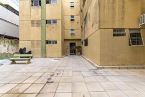 an empty courtyard with a bench in front of a building at Apartamentos com internet rápida in Maceió