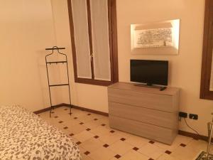 a bedroom with a flat screen tv on a dresser at B&B Via Garibaldi in Lonigo